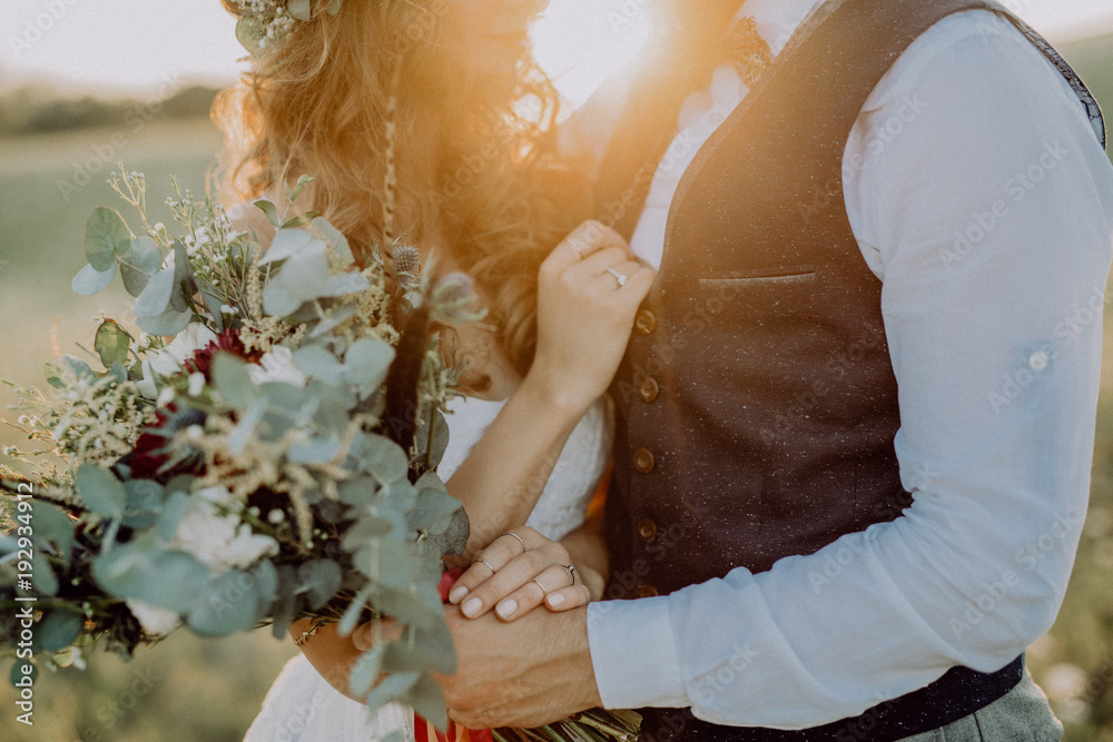 Wall mural beautiful bride and groom at sunset in green nature.