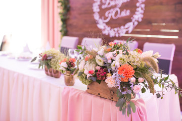 Rustic flower arrangement at a wedding banquet. Table set for an event party or wedding reception.