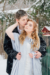 Couple on nature in winter during a snowfall