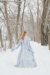 Fototapeta na wymiar Beautiful girl under the snowfall
