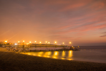 Fototapeta na wymiar Sea and pier with lanterns in a night