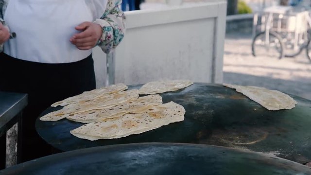 Cooking traditional Turkish food Gozleme(pastries,pancake-) on the stove.Closeup on the bake.