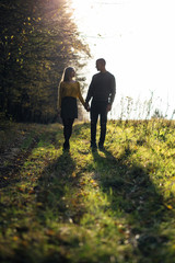 Obraz premium The lovely couple in love walking along park