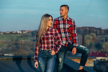 The lovely couple in love standing on the roof