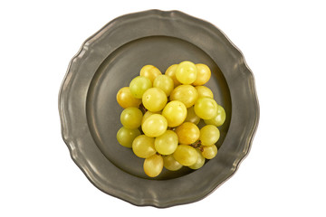 Kiść zielonych winogron na metalowym talerzu, centralnie z góry na białym tle