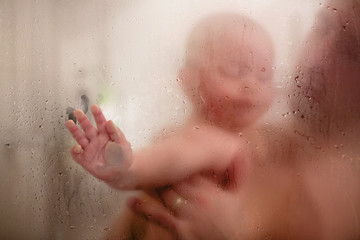 Father and baby boy in shower, drops of water