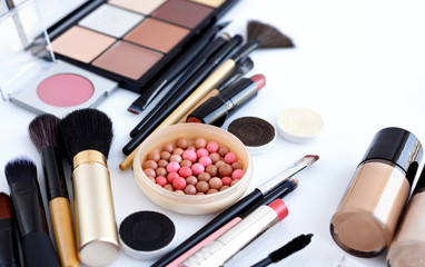 Makeup brush and decorative cosmetics on a white background