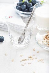 Glass  with spoon  in  oat flakes and milk for healthy breakfast.