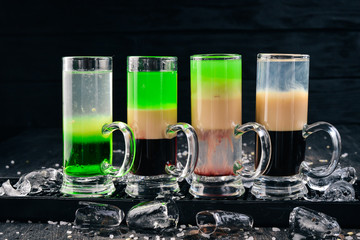 Set of alcoholic cocktails. Bar. On a black wooden background.
