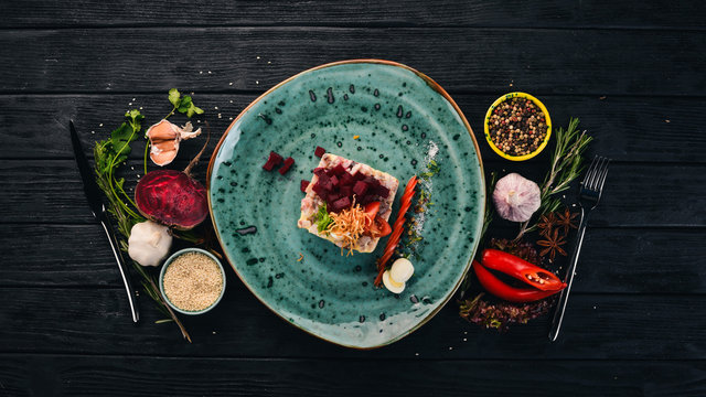 Russian traditional cuisine. Shub salad with herring. Top view. On a black wooden background. Copy space.