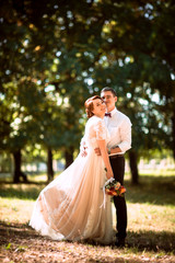 The bride and groom in the background of park trees