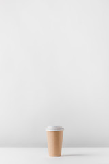 one disposable coffee cup on white table