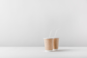 two disposable coffee cups on white surface
