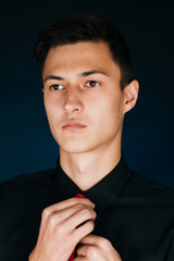 Portrait young guy on a dark studio
