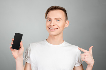 Young man showing a blank smart phone screen