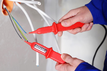 Elektriker installiert Steckdosen, verlegt Kabel 