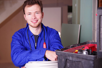 Handwerker auf einer Baustelle lächelt positiv in die Kamera 