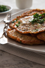 Vegetable pancakes with parsley on white plate