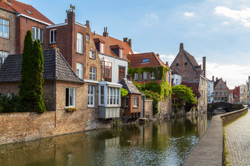 Fototapeta na wymiar Typical view of Bruges (Brugge), Belgium with red brick houses with triangle shaped roofs and canals