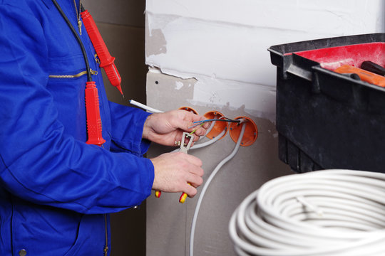 Elektriker installiert Steckdosen, verlegt Kabel 