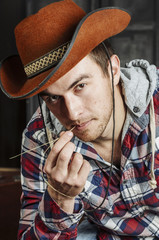 Portrait of a Cowboy. dark hair, jeans , plaid shirt.