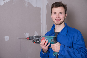 Mann mit einer Bohrmaschine auf einer Baustelle 