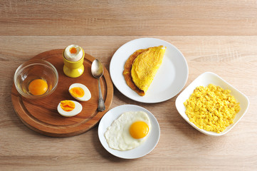 Different ways of cooking dishes from chicken eggs. Omelette, soft-boiled, hard-boiled, fried, scrambled eggs. In a glass bowl, a raw egg without a shell. 