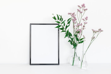 Flowers composition. Photo frame, pink flowers, green leaves on white background. Front view, copy space, mock up