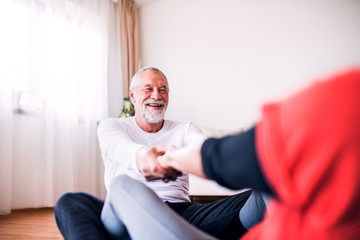 Senior couple doing exercise at home.