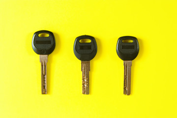  Three keys from the doors on a bright yellow background. Flat lay. Objects