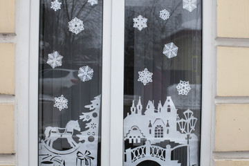 Window with christmas decorations and old snow drift.