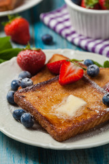 Traditional, delicious, sweet French toast with fruit and butter.