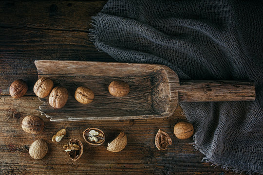 .Walnuts in a wooden scoop on an old village table. Low key.