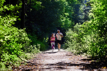 Athletic man and woman doing Jogging in the woods.