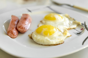 2 fried eggs with sausages on the plate, cooked food products