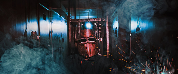 man worker mask sparks smoke dark room