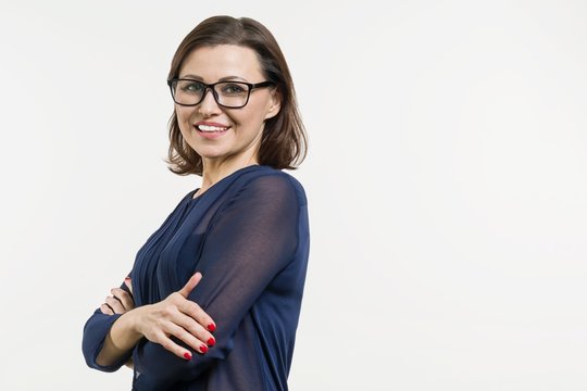 Smiling middle aged woman with folded arms on white background