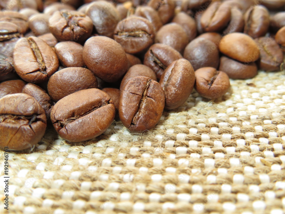 Wall mural coffee beans on burlap closeup