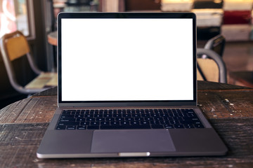 Fototapeta premium Mockup image of laptop with blank white desktop screen on wooden table in modern cafe