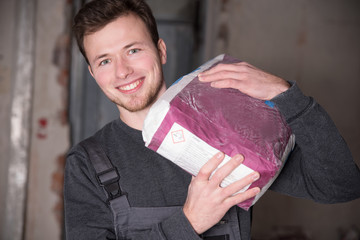 Arbeiter trägt einen Sack Zement 