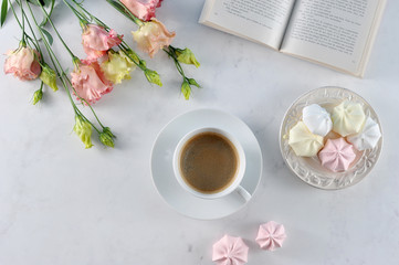 Sweet dreams ... A book, a cup of coffee, meringue, flowers. Romantic and gentle compassion. Light background. Close-up. View from above.