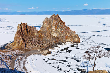 Baikal Lake in spring morning. Olkhon Island. The ice cracked and began to melt near the Shamanka Rock