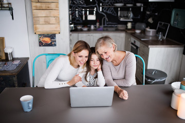 A small girl with mother and grandmother at home.