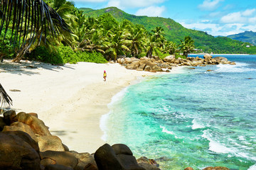 woman walking on tropical beach at seychelles, south of mahe, Petite marie louise bay