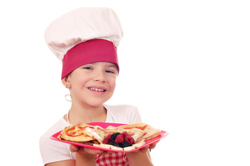 happy little girl cook with sweet crepes