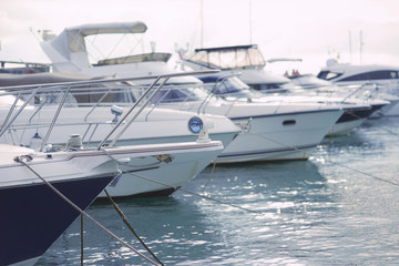 Fototapeta premium Yachts on the pier in the port in cloudy weather 