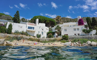 Waterfront houses on the Mediterranean sea shore with sand and rocks, Spain on the Costa Brava, Catalonia, Canyelles Petites, Roses, Girona, seen from water surface
