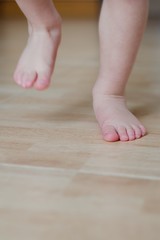 Baby foot running on a tiled floor