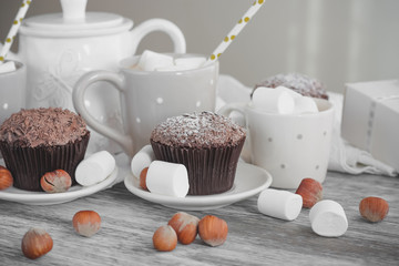 Cups with cacao and marshmallow, cupcakes and different decorations