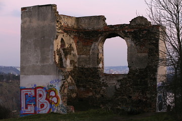Ruins of old house covered by vandals in the evening light